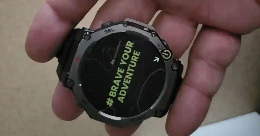 Amazfit T-Rex 3 smartwatch on a rocky trail with mountains in the background, showcasing its rugged design.